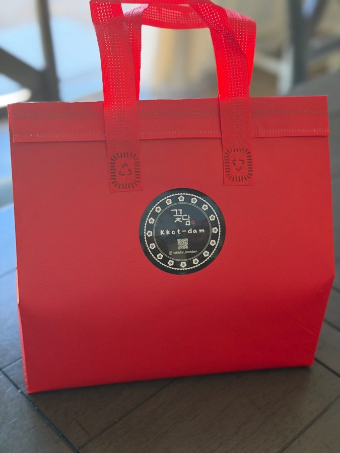 Red insulated Kkot-dam carry bag with handles and the Kkot-dam logo sticker